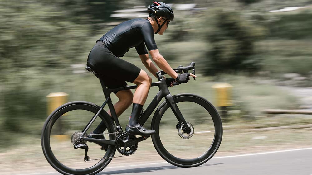 Cyclist melaju dengan sepeda road bike menghadapi terpaan angin