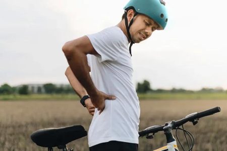 Cyclist Is Experiencing Discomfort While Riding A Bicycle.