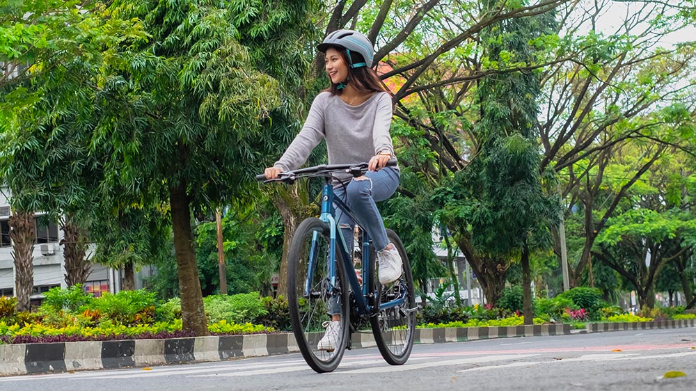 An individual cycling through an urban area on a Polygon city bike.