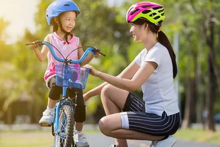 Parents Preparing To Cycle With Their Little One