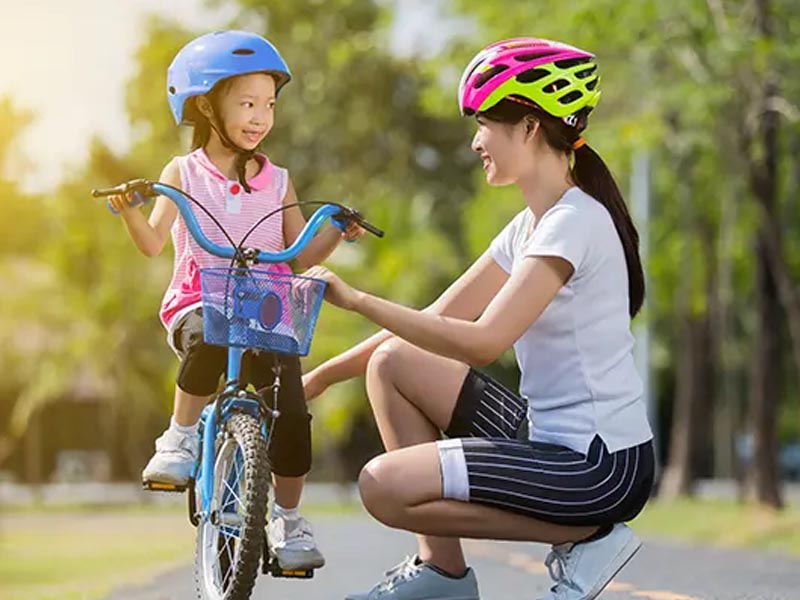 Parents Preparing To Cycle With Their Little One