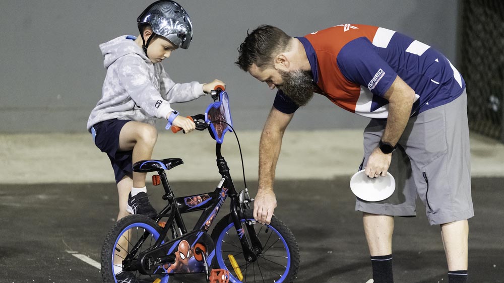 Parent performing a quick safety check on a junior bike