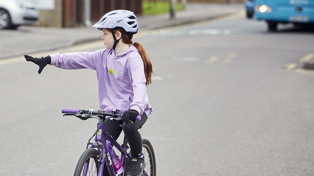 A kid demonstrating basic bike hand signals