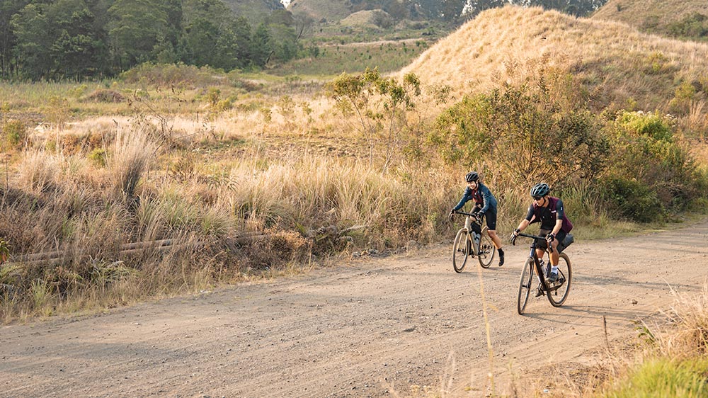 Rider exploring mixed terrain on a gravel touring bike