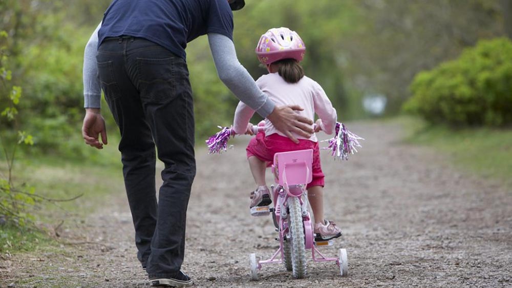 Smiling boy riding his kids bicycle outdoors