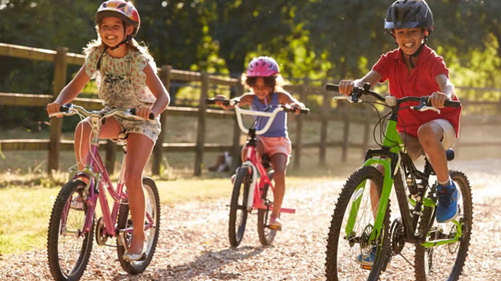 Young boy struggling to ride a bike that’s too big
