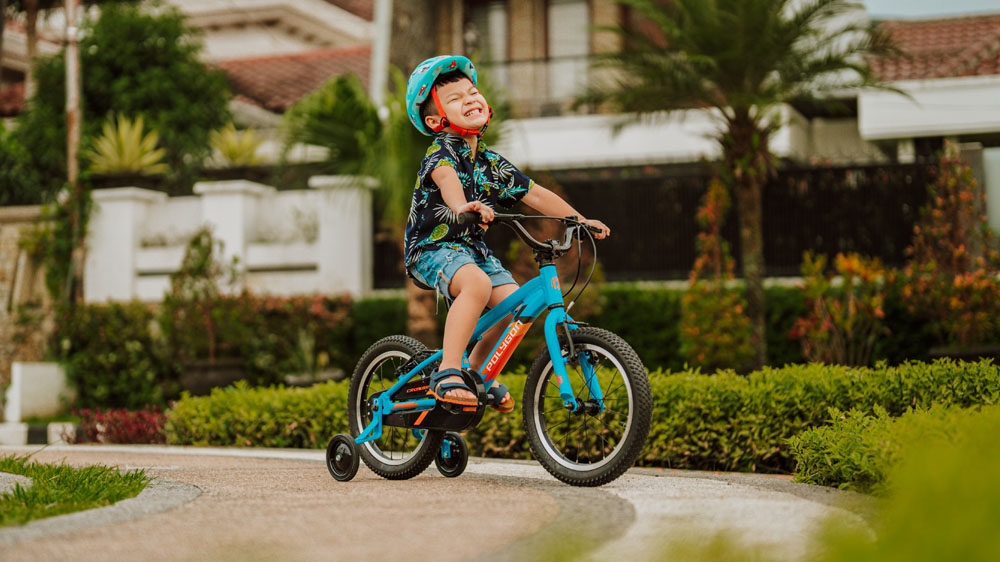  A Young Boy That Is Happy Playing With His Kids Bike